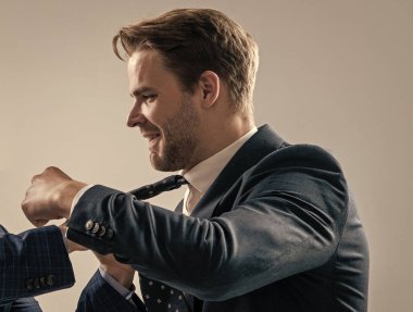 Karşılık olarak yumruk atıldı. Profesyonel erkek yumruğu kravat tarafından çekiliyor. İşyeri şiddeti