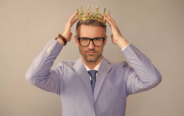 успешный высокомерный человек носит корону короля. успех и вознаграждение.