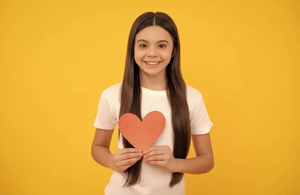 Gelukkig kind met rood hart op gele achtergrond, liefde — Stockfoto