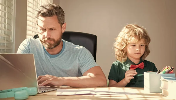 Κατ 'οίκον διδασκαλία και μάθηση. Πίσω στο σχολείο. σοβαρός πατέρας και γιος χρησιμοποιούν υπολογιστή στο σπίτι. — Φωτογραφία Αρχείου