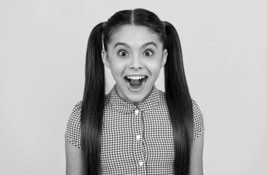 Ne hoş bir sürpriz. Kız şaşkınlıkla ağzını açık tutuyor. Şaşkın çocuk sarı arka plan