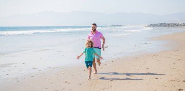 Baba ve oğul yaz plajında koşuyor. Aile seyahati ve tatil.