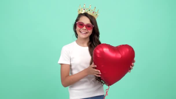 Happy teen girl winner in sunglasses and queen crown with heart party balloon, pageant — Stockvideo