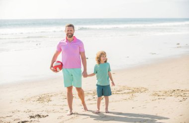 kid and dad walking on beach in summer vacation holding ball, summer