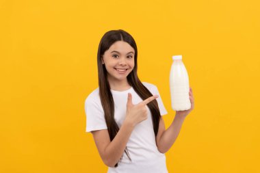 happy child point finger on dairy beverage product. teen girl going to drink milk.
