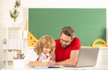 Öğretmen ve çocuk eğitimi sınıfta dizüstü bilgisayarla, babalıkla