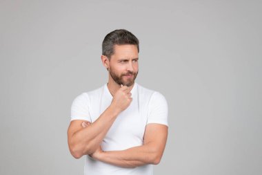 Beyaz tişörtlü, düşünceli, düşünceli, düşünceli bir adam.