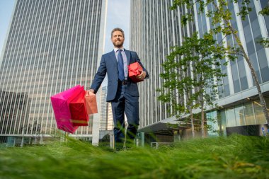 boxing day. handsome man with present box. boss carry birthday gift. guy hold shopping bags