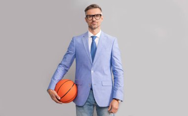 Gri arka planda basketbol topu tutan gülen gri adam, iş dünyası