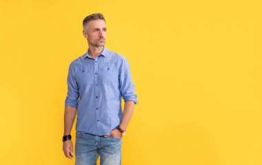 adult man with hand watch on yellow background, copy space, fashion