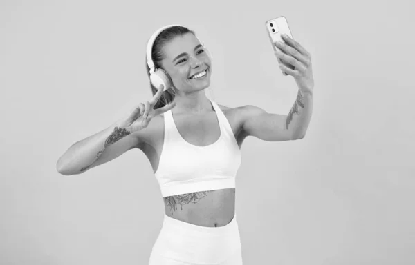 Fones de ouvido mulher feliz fazendo selfie no smartphone e ouvir música, tecnologia moderna. — Fotografia de Stock