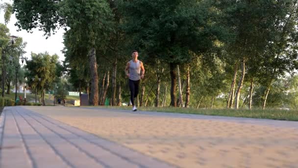 Outdoor exercise of sporty man running in park, sprinting — стоковое видео