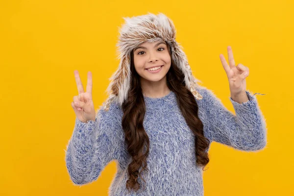 Happy kid long hair in hat show peace gesture on yellow background, fashion — 图库照片
