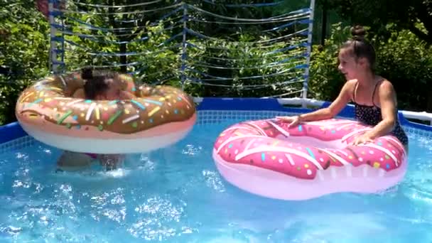 Happy girls enjoy swimming and floating in children pool during summer vacation, fun — Video Stock