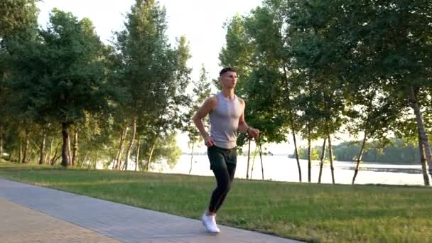 Outdoor workout of sporty man running in park, sport routine — Stockvideo