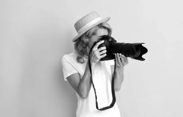 Profesjonalna kobieta fotograf z aparatem fotograficznym w słomkowym kapeluszu podejmowania zdjęć, fotografowanie — Zdjęcie stockowe
