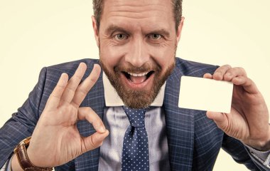 happy businessman man in businesslike suit showing empty debit or business card for copy space