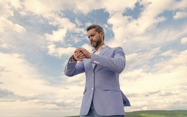 Yetişkin bir iş adamı. İş başarısı. Mavi takım elbiseli ve kol saati takan adam..