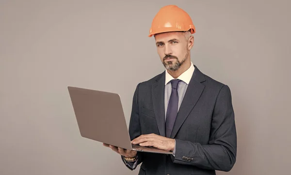 Mature businessman working online on project. agile business success. entrepreneur in helmet use pc. — Stock Photo, Image