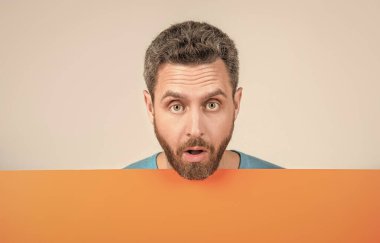 Turuncu siyah pankartın arkasında bilgi için fotokopi alanı olan olgun sakallı bir adam, satıcı.