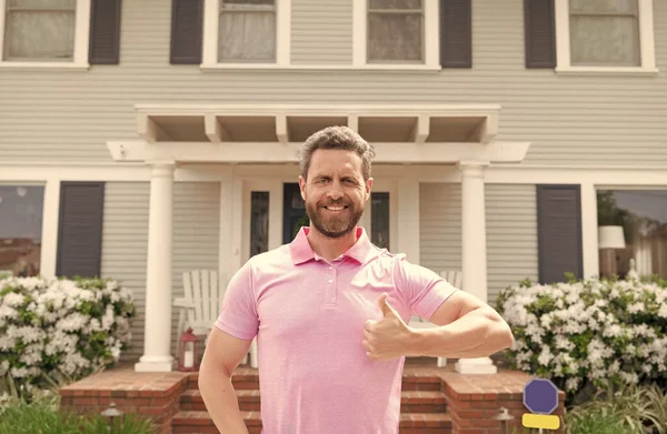 Happy owner show thumb up. ownership. confident man outside new american home. — Stock Photo, Image