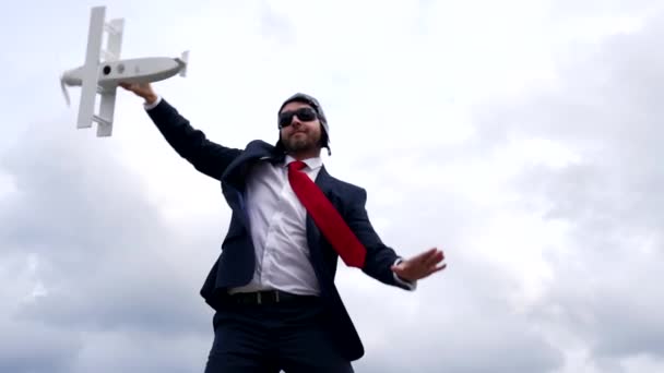 Бізнесмен запускає іграшковий літак на фоні неба, бізнес-пілот — стокове відео