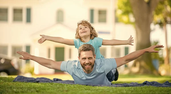 Día libre de padre feliz con el niño relajarse juntos en la hierba verde parque, cuidado de niños —  Fotos de Stock