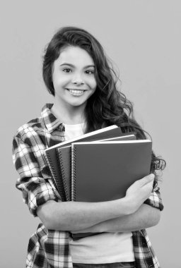 Neşeli çocuk ödevlerini kitaplarla yapacak. Gülümseyen öğrenci. eğitim ve bilgi.