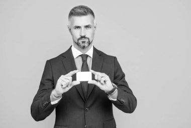 Takım elbiseli, gri saçlı olgun bankacı kredi kartı fotokopi alanı gösteriyor, müdür.