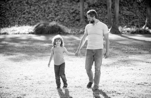 Gelukkige familiewaarde. jeugd en ouderschap. ouder leidt kleine kind jongen op gras. — Stockfoto