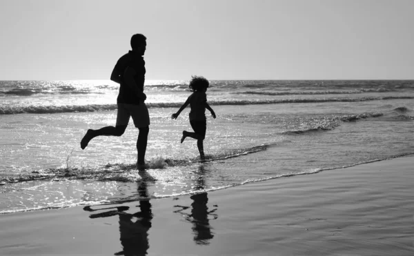 Padre e hijo siluetas corriendo divertirse y sentir la libertad en la playa de verano, vacaciones de verano —  Fotos de Stock