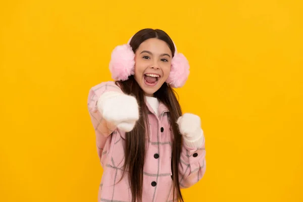 Menina adolescente feliz no inverno mitenes e auriculares perfurando no fundo amarelo, felicidade — Fotografia de Stock
