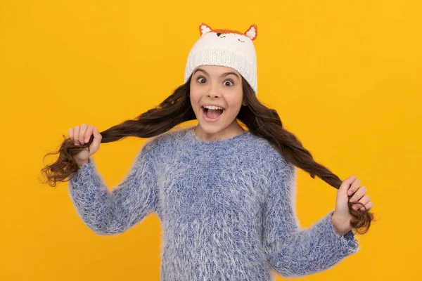 Wintermode. Verbaasd blij kind met krullend haar in hoed. vrouwelijk modemodel. tiener meisje — Stockfoto