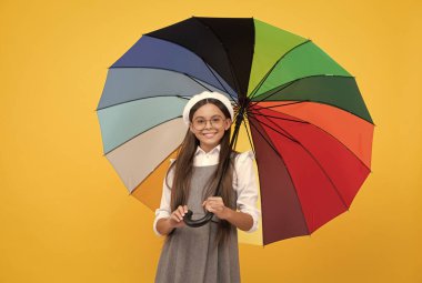 Okula dönüyorum. Canlı yağmurdan korunan bir çocuk. Gözlüklü mutlu liseli kız. Neşeli genç çocuk