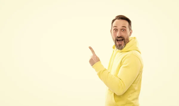 Happy man in hoody pointing finger on copy space isolated on white, suggest. — Stock Photo, Image