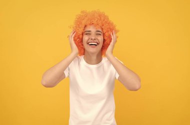 Ben çok mutluyum. Olumlu duygularını ifade et. Neşeli bayan peruk takıyor. Kadının turuncu saçları var..