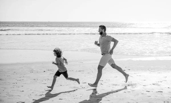 Szczęśliwy tata i dziecko baw się dobrze na świeżym powietrzu. ojciec i syn biegający po letniej plaży. — Zdjęcie stockowe