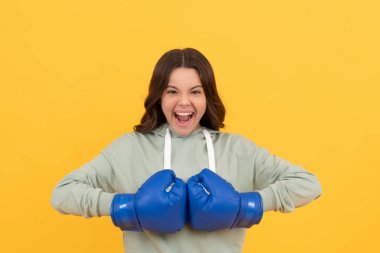 Sarı arka planda boks eldivenli bağıran çocuk, spor