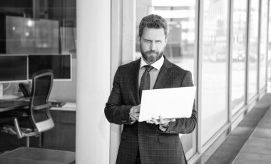 İşletme bürosunda bilgisayar üzerinde çalışan iş adamı kılığındaki yakışıklı girişimci, müdür..