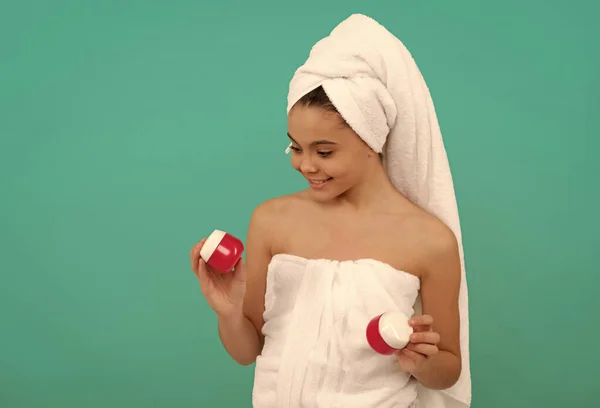 Presentatie cosmetische product voor tiener. Het kind gebruikt gezichtscrème. gelukkig meisje kiezen haarmasker. — Stockfoto