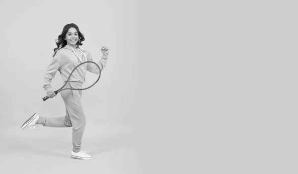 Feliz adolescente enérgico salto con raqueta de bádminton corriendo hacia el éxito, espacio de copia, lleno de energía —  Fotos de Stock