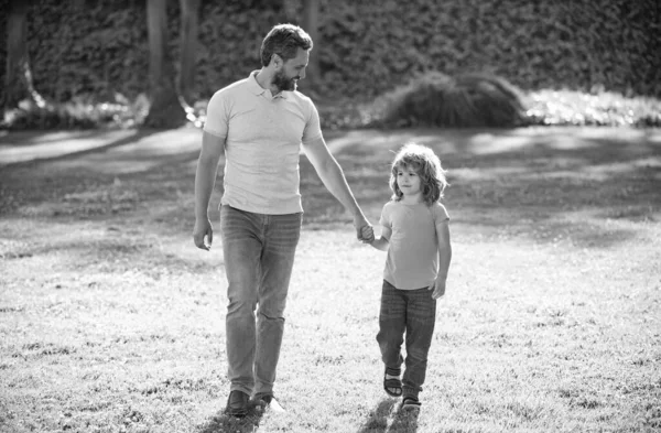 Infância e paternidade. pai com menino na grama. pai com menino no verão — Fotografia de Stock