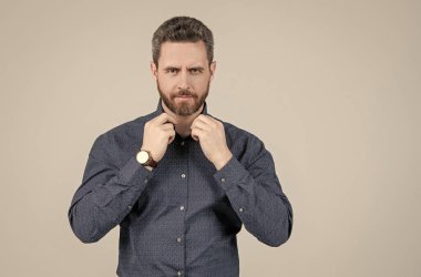 Zahmetsizce zeki görünüyorsun. Tıraşsız adam düğmesi, gri arka plan. Sıradan giyinmiş.