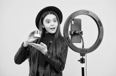 Çocuk güzellik blogcusu. Neşeli çocuk makyaj yapar. Kozmetik ile video kaydedici. Telefonda video günlüğü oluşturuluyor.