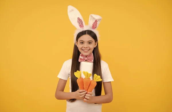 Gelukkig pasen kind meisje in konijnenoren en strikje houden wortel, gelukkig Pasen — Stockfoto
