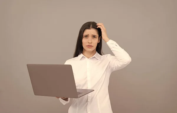 Zavaros nő fehér ingben hold számítógép van egy csomó munka, probléma — Stock Fotó