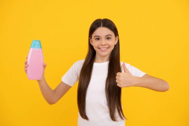 Günlük alışkanlıklar ve kişisel bakım. Vücut bakımı kozmetik. Başparmağını kaldır. Neşeli kız şampuanı tut.