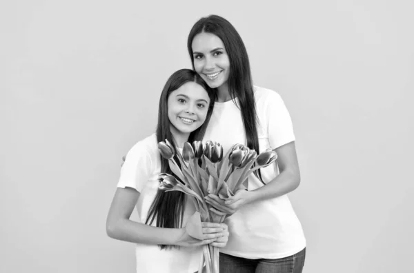 Filha feliz menina e mãe segurar buquê de flores de tulipa primavera para 8 Março de férias, dia das mulheres — Fotografia de Stock