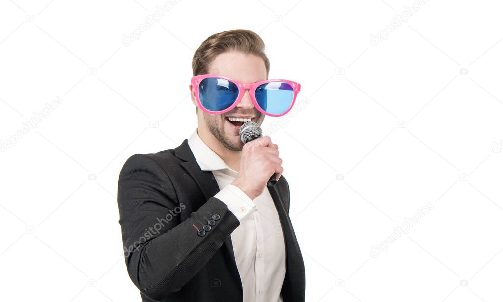 Happy funny man businessman in party glasses sing song to microphone, karaoke