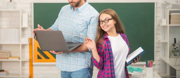 Ostříhaný otec a šťastné dítě studium ve škole s knihou a notebookem na tabuli pozadí, škola — Stock fotografie